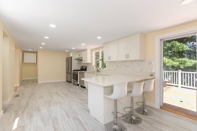 43 Hobart Ter, Braintree, MA 02184 - kitchen featuring stainless steel appliances, under cabinet range hood, tasteful backsplash, light countertops, and recessed lighting