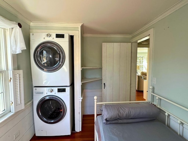 laundry area with laundry area, stacked washer / dryer, wood finished floors, and ornamental molding