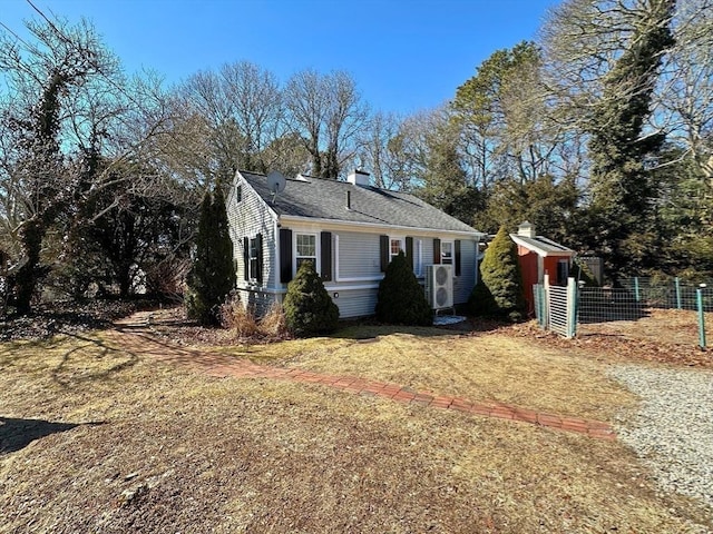 view of front of house with a front lawn, fence, roof with shingles, and a chimney