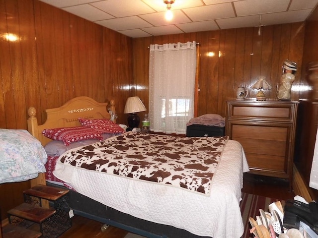 bedroom with wood walls and wood finished floors