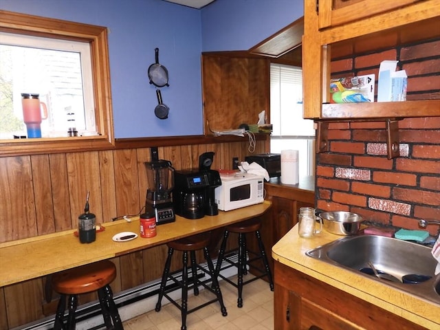 kitchen featuring a wainscoted wall, white microwave, and wood walls