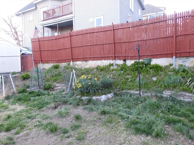 view of yard with fence and a balcony