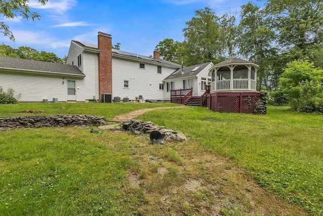 37 Colonial Way, Rehoboth, MA 02769 - back of property with a wooden deck, a sunroom, a yard, and a gazebo