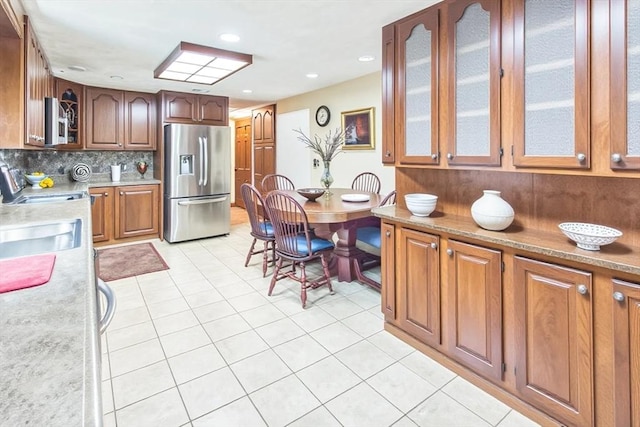 37 Colonial Way, Rehoboth, MA 02769 - kitchen featuring stainless steel fridge, glass insert cabinets, light countertops, light tile patterned floors, and decorative backsplash