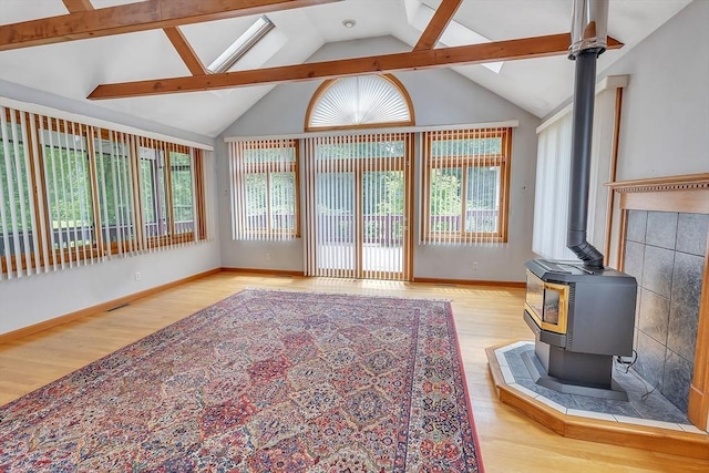 37 Colonial Way, Rehoboth, MA 02769 - unfurnished living room with light wood-type flooring, a wood stove, and lofted ceiling