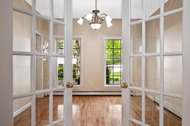 unfurnished sunroom with a chandelier and a baseboard radiator