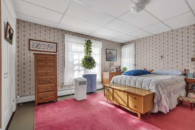 bedroom featuring carpet floors, a baseboard heating unit, and a paneled ceiling