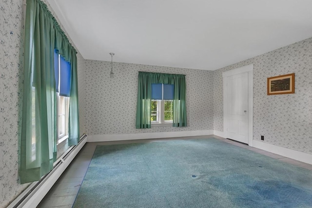 carpeted spare room with a baseboard radiator