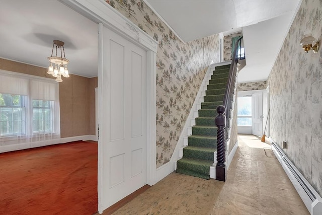 staircase with carpet floors, a notable chandelier, and a baseboard radiator