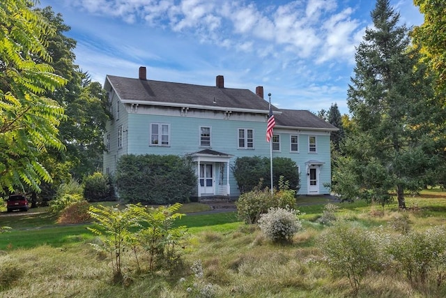 rear view of house featuring a yard