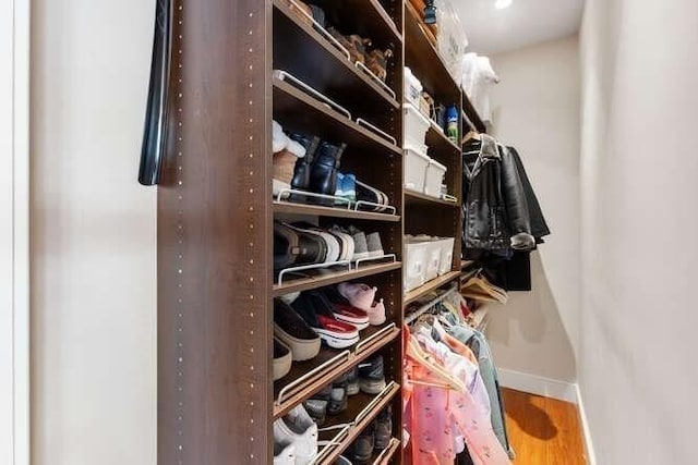 walk in closet with wood finished floors
