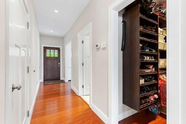 corridor featuring wood finished floors and baseboards