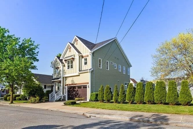view of side of home with board and batten siding, a garage, and concrete driveway