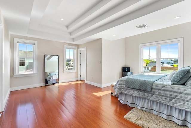 bedroom featuring a raised ceiling, hardwood / wood-style flooring, baseboards, and recessed lighting