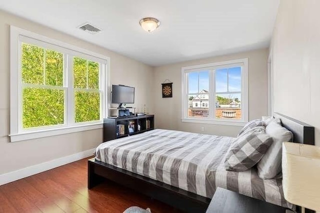bedroom with wood finished floors and baseboards