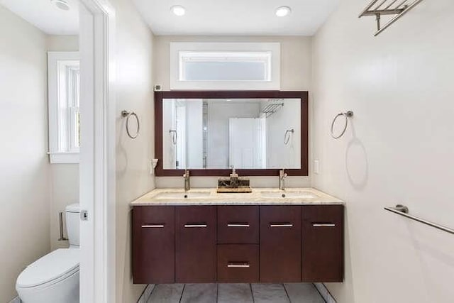 full bath featuring toilet and double vanity