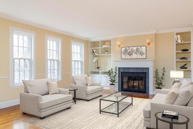 living room featuring built in shelves, plenty of natural light, wood finished floors, and ornamental molding