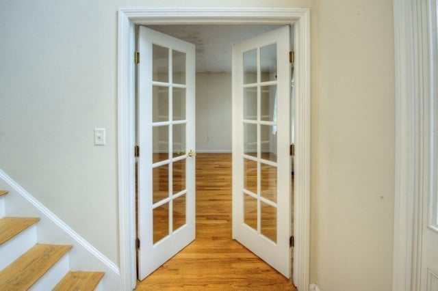 doorway with french doors and light wood-type flooring