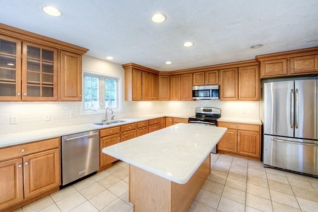 kitchen featuring stainless steel appliances, a center island, sink, and decorative backsplash