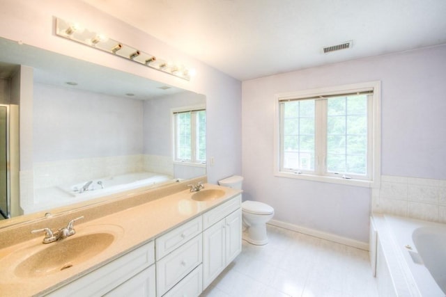 bathroom featuring vanity, toilet, and a washtub