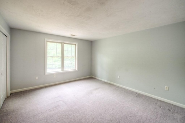 empty room featuring carpet floors and a textured ceiling