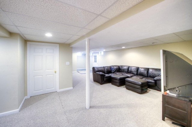 living room featuring light carpet and a drop ceiling