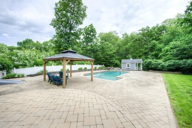 view of pool with a shed, a gazebo, and a patio area