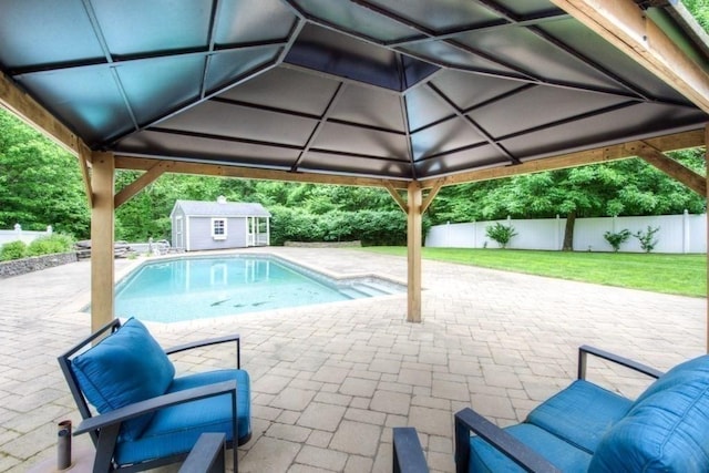 view of pool with a shed, a yard, and a patio