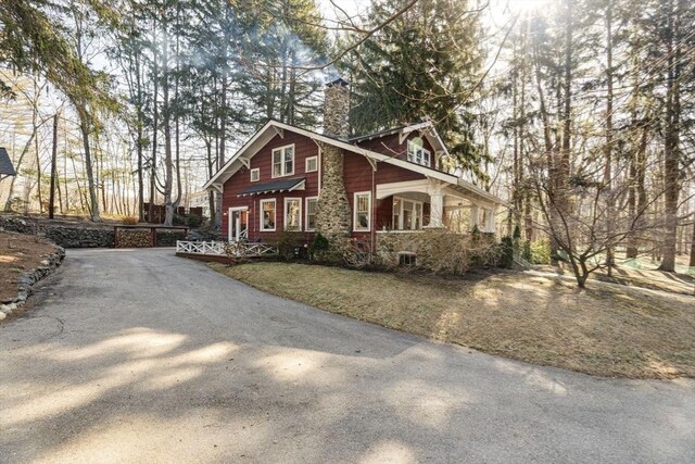 view of front facade with a front yard and a chimney