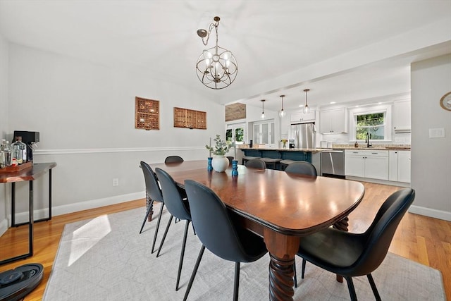 10 Stoughton Rd, Dedham, MA 02026 - dining area with light wood finished floors, baseboards, and a chandelier