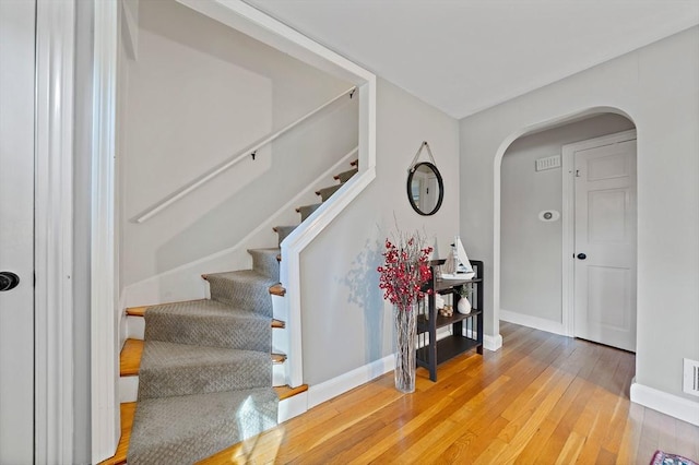 10 Stoughton Rd, Dedham, MA 02026 - stairs with hardwood / wood-style flooring, arched walkways, and baseboards