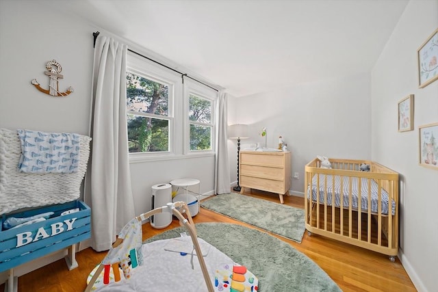 10 Stoughton Rd, Dedham, MA 02026 - bedroom featuring a nursery area, wood finished floors, and baseboards