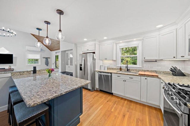 10 Stoughton Rd, Dedham, MA 02026 - kitchen with stainless steel appliances, a sink, a kitchen breakfast bar, white cabinetry, and light wood finished floors