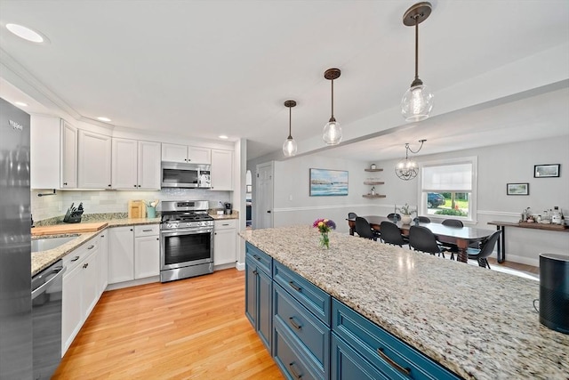 10 Stoughton Rd, Dedham, MA 02026 - kitchen featuring appliances with stainless steel finishes, blue cabinetry, white cabinets, light wood-style floors, and recessed lighting