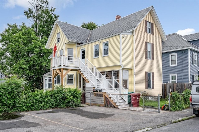 34 May St, Lowell, MA 01850 - view of front of property featuring stairway, a chimney, a shingled roof, and uncovered parking