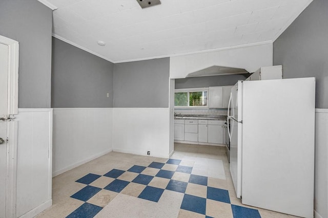 34 May St, Lowell, MA 01850 - kitchen featuring freestanding refrigerator, light floors, white cabinetry, wainscoting, and ornamental molding