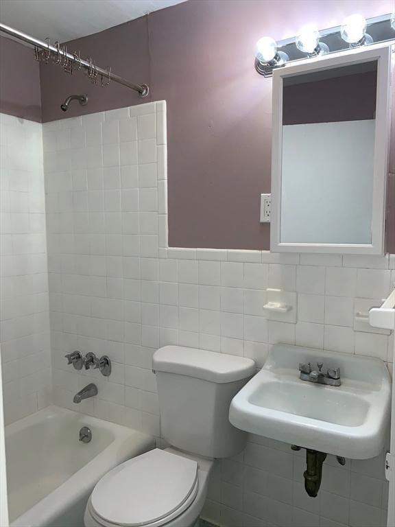 full bathroom featuring toilet, shower / tub combination, a sink, and tile walls