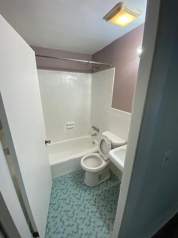 bathroom with toilet, tile patterned floors, bathing tub / shower combination, and a sink