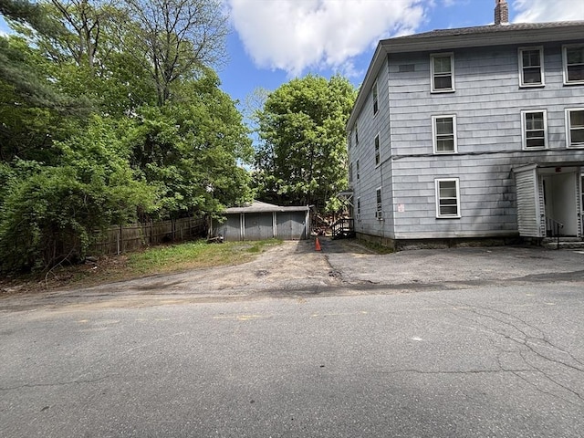 view of side of property featuring a chimney and fence
