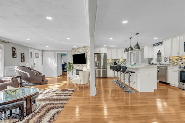 living room with a fireplace, light hardwood / wood-style floors, and crown molding