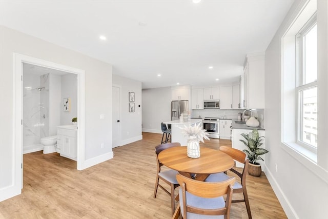 dining room featuring recessed lighting, light wood-style flooring, and baseboards