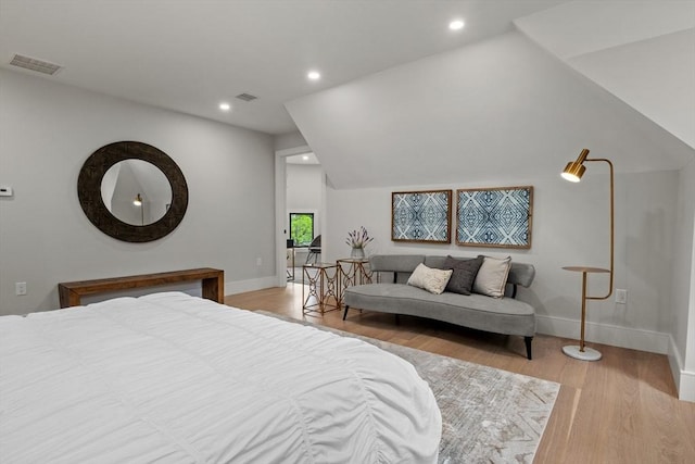 bedroom with baseboards, wood finished floors, and recessed lighting