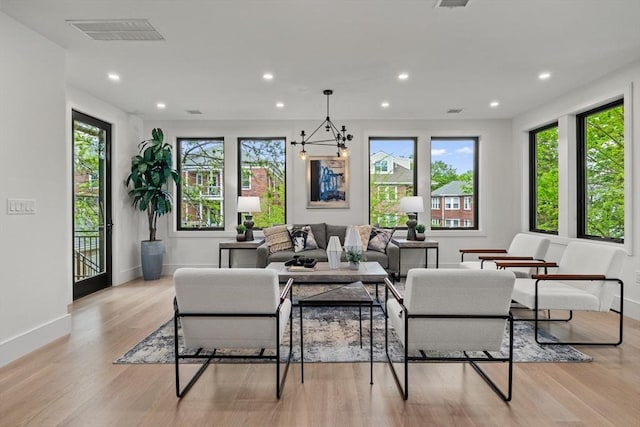 living area with recessed lighting, light wood finished floors, baseboards, and a chandelier