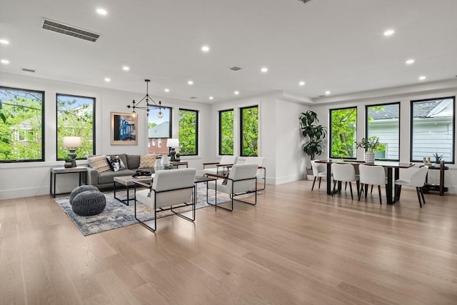 living room with baseboards, healthy amount of natural light, recessed lighting, and light wood-type flooring