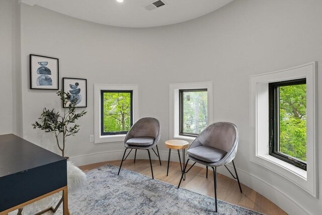 living area featuring healthy amount of natural light, wood finished floors, and baseboards