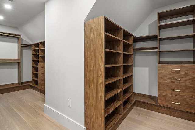 walk in closet featuring wood finished floors and lofted ceiling