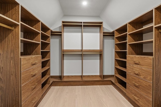 walk in closet featuring vaulted ceiling and wood finished floors