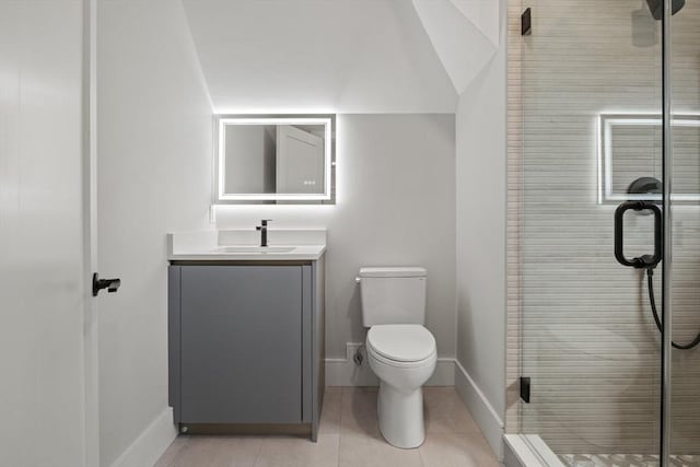 bathroom featuring vanity, a stall shower, toilet, tile patterned flooring, and baseboards
