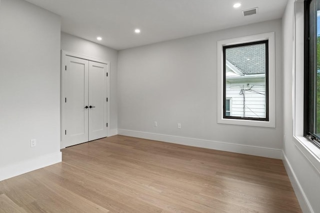spare room with light wood-type flooring, baseboards, and recessed lighting