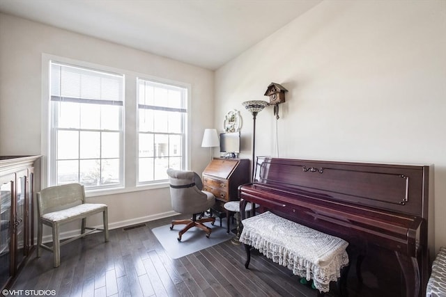 sitting room with dark wood-style flooring, baseboards, visible vents, and plenty of natural light
